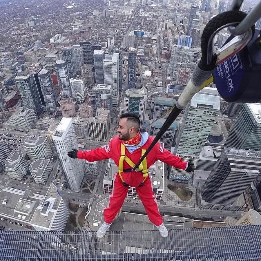 Jonathan Campoy, fundador de Yei, con los brazos abiertos en la orilla de la CN Tower sobre Toronto